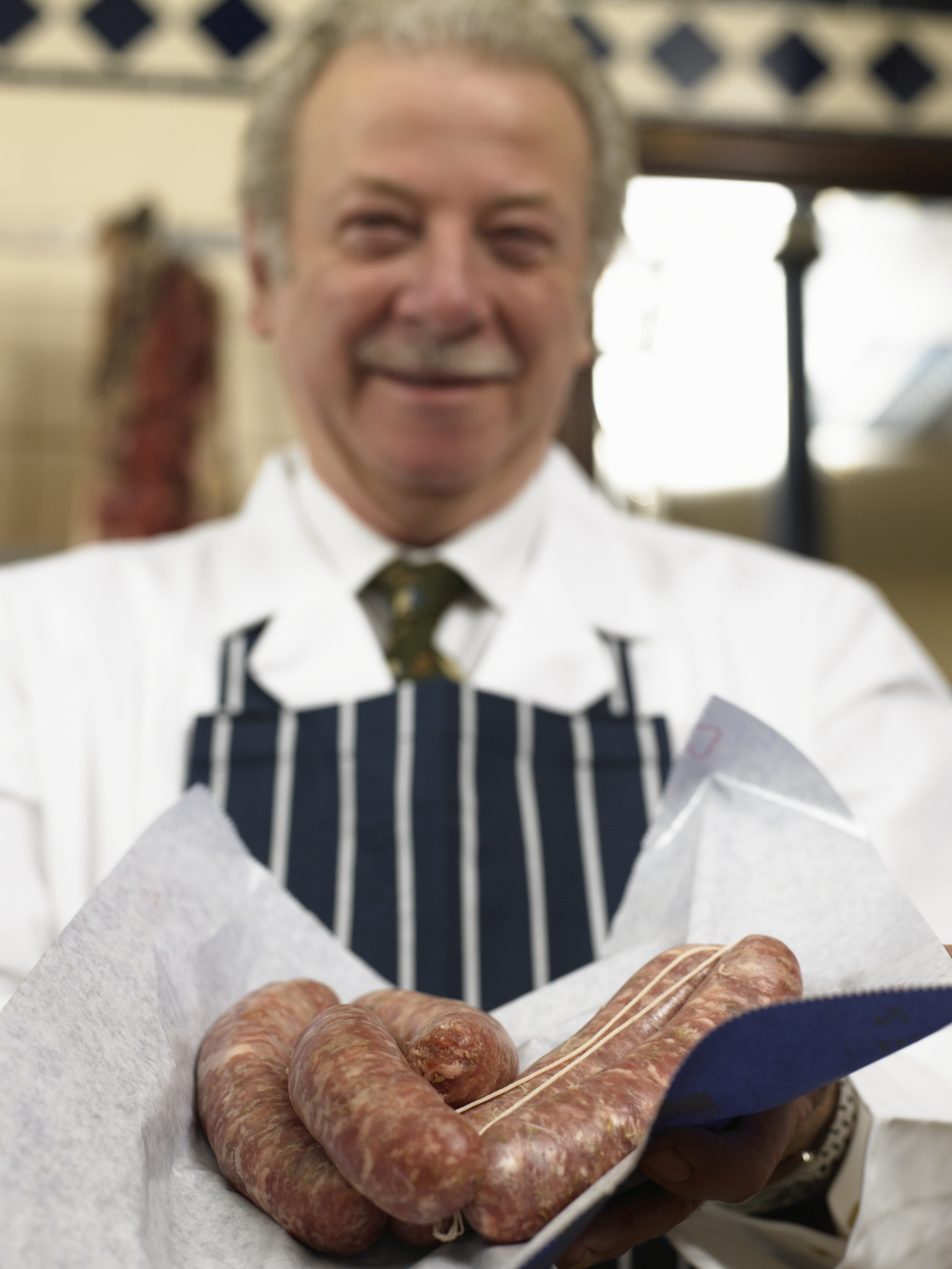 Butcher with striped apron and sausages