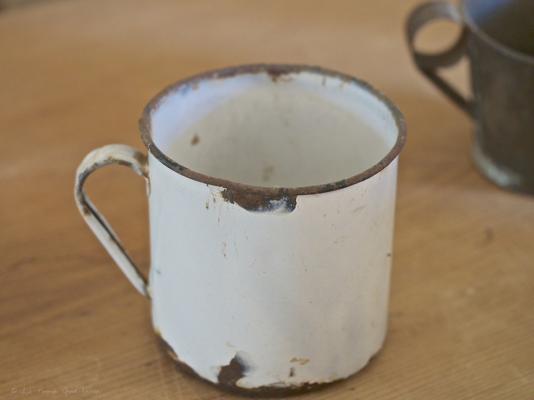 Old enamel cup on the kitchen table at Cooma Cottage 